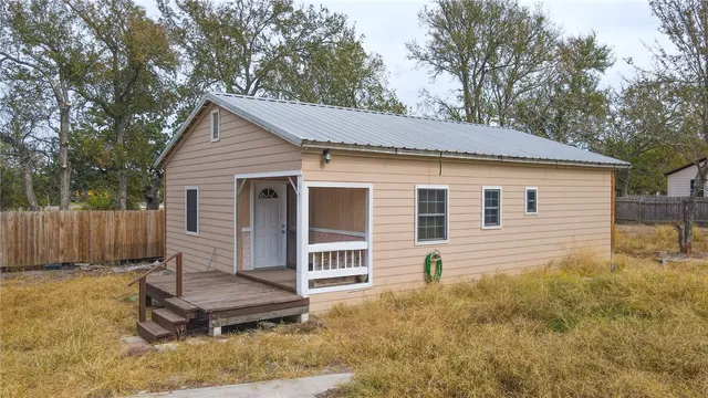 a view of a house with a yard and wooden fence