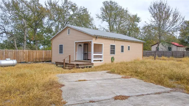 a view of a house with backyard and trees