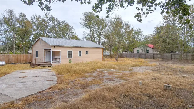 a view of a white house with a yard and garage