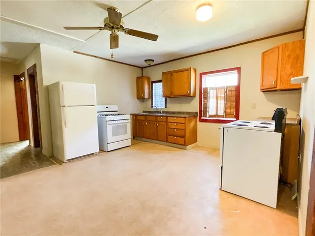 a kitchen with stainless steel appliances granite countertop a refrigerator a stove and a sink with cabinets