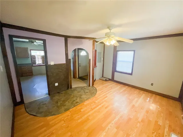 a view of a livingroom with wooden floor and a ceiling fan