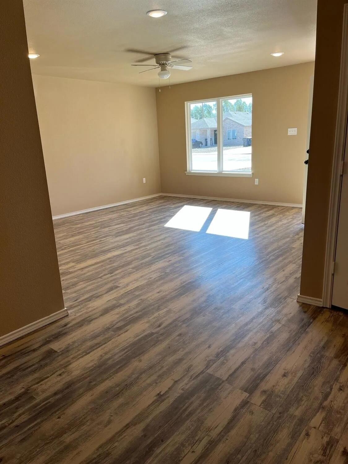 2425 N Avenue North Lubbock, TX 79403 - Photo 4 of 9 an empty room with wooden floor and windows