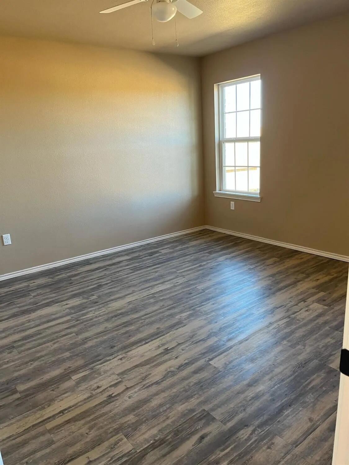 2425 N Avenue North Lubbock, TX 79403 - Photo 5 of 9 wooden floor in an empty room with a window
