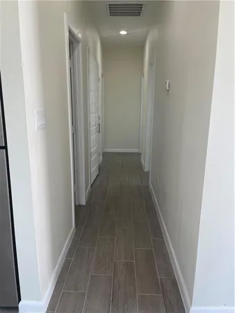 a view of a hallway with wooden floor