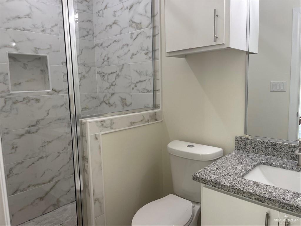 405 Rafael Drive, Unit 2 San Juan, TX 78589 - Photo 6 of 9 a bathroom with a granite countertop toilet and a sink