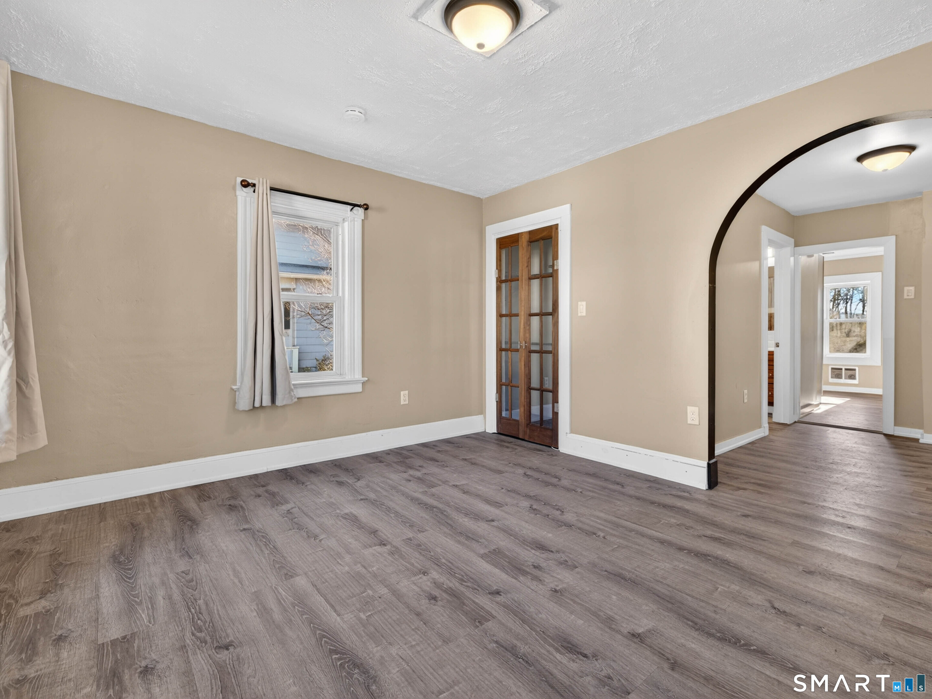 97 Woodland Street Meriden, CT 06451 - Photo 13 of 35 an empty room with wooden floor and windows