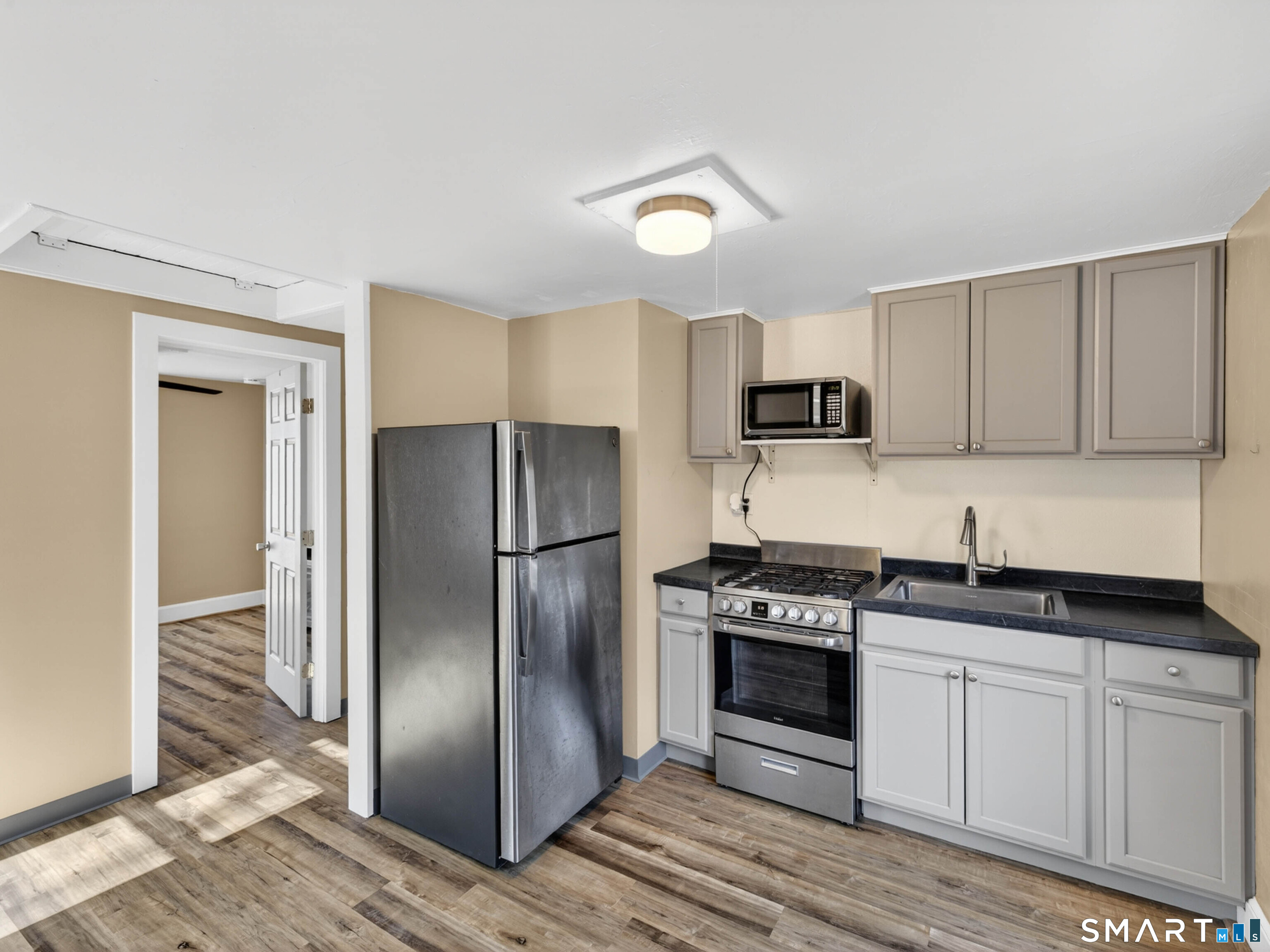 97 Woodland Street Meriden, CT 06451 - Photo 20 of 35 a kitchen with granite countertop a refrigerator and a stove top oven