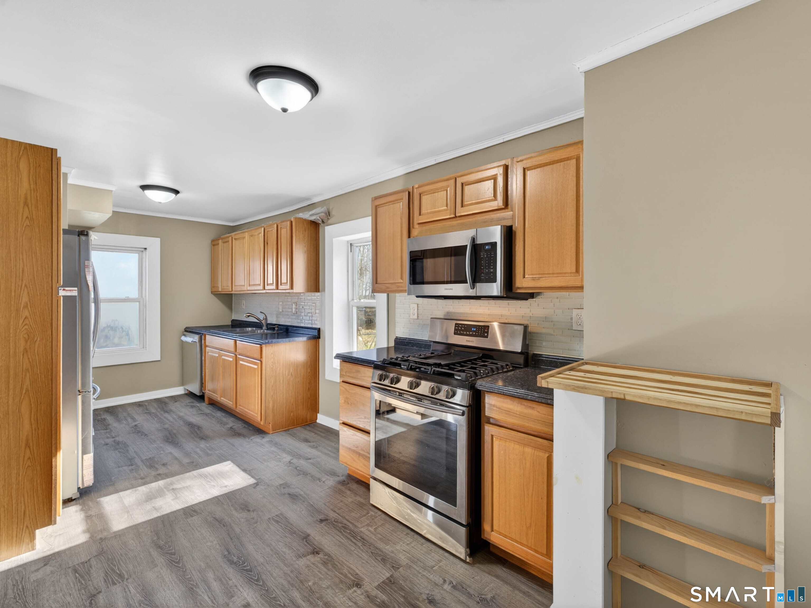 97 Woodland Street Meriden, CT 06451 - Photo 2 of 35 a kitchen with granite countertop a stove top oven and cabinets