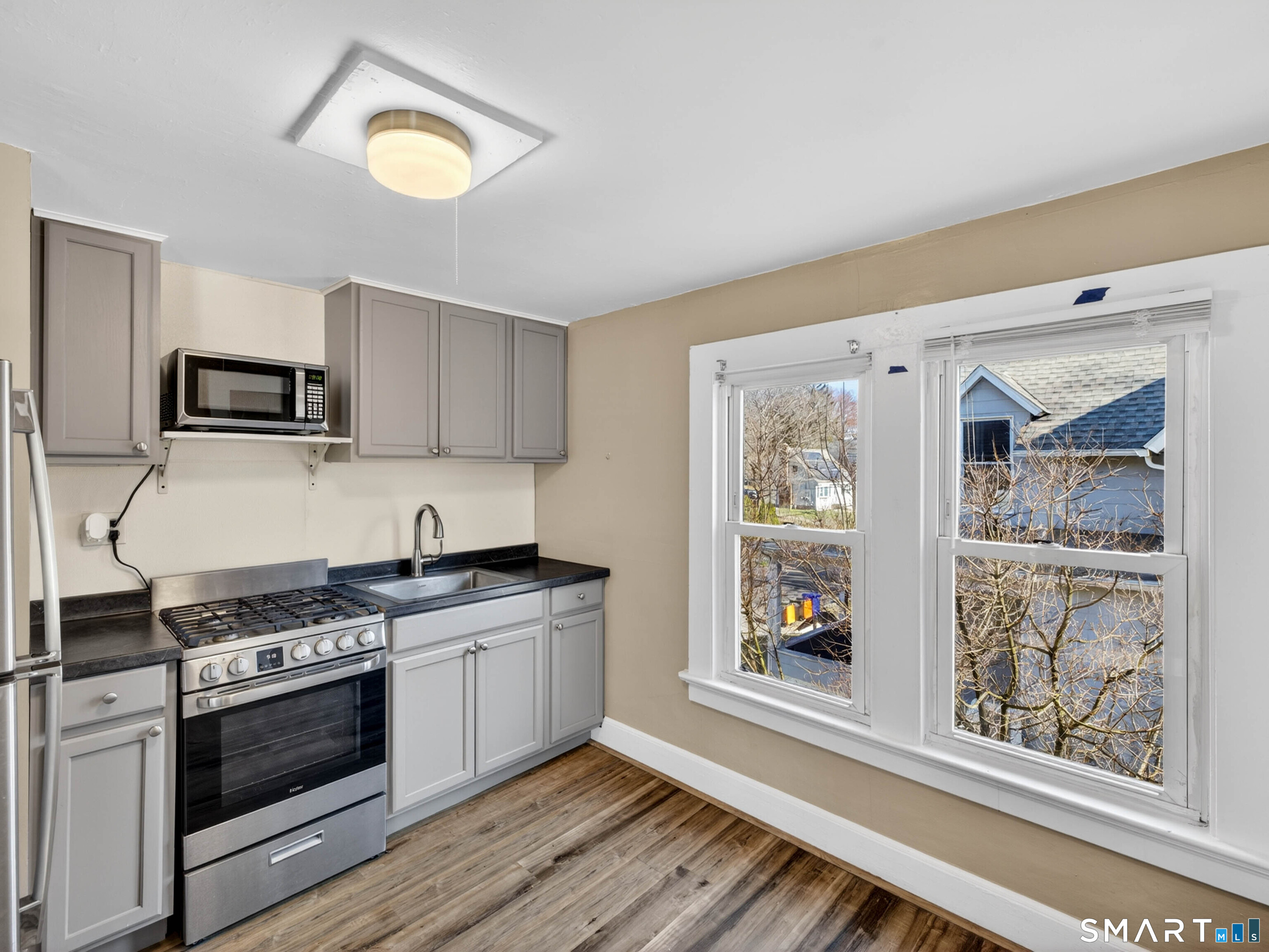 97 Woodland Street Meriden, CT 06451 - Photo 22 of 35 a kitchen with stainless steel appliances granite countertop a stove a sink and a microwave