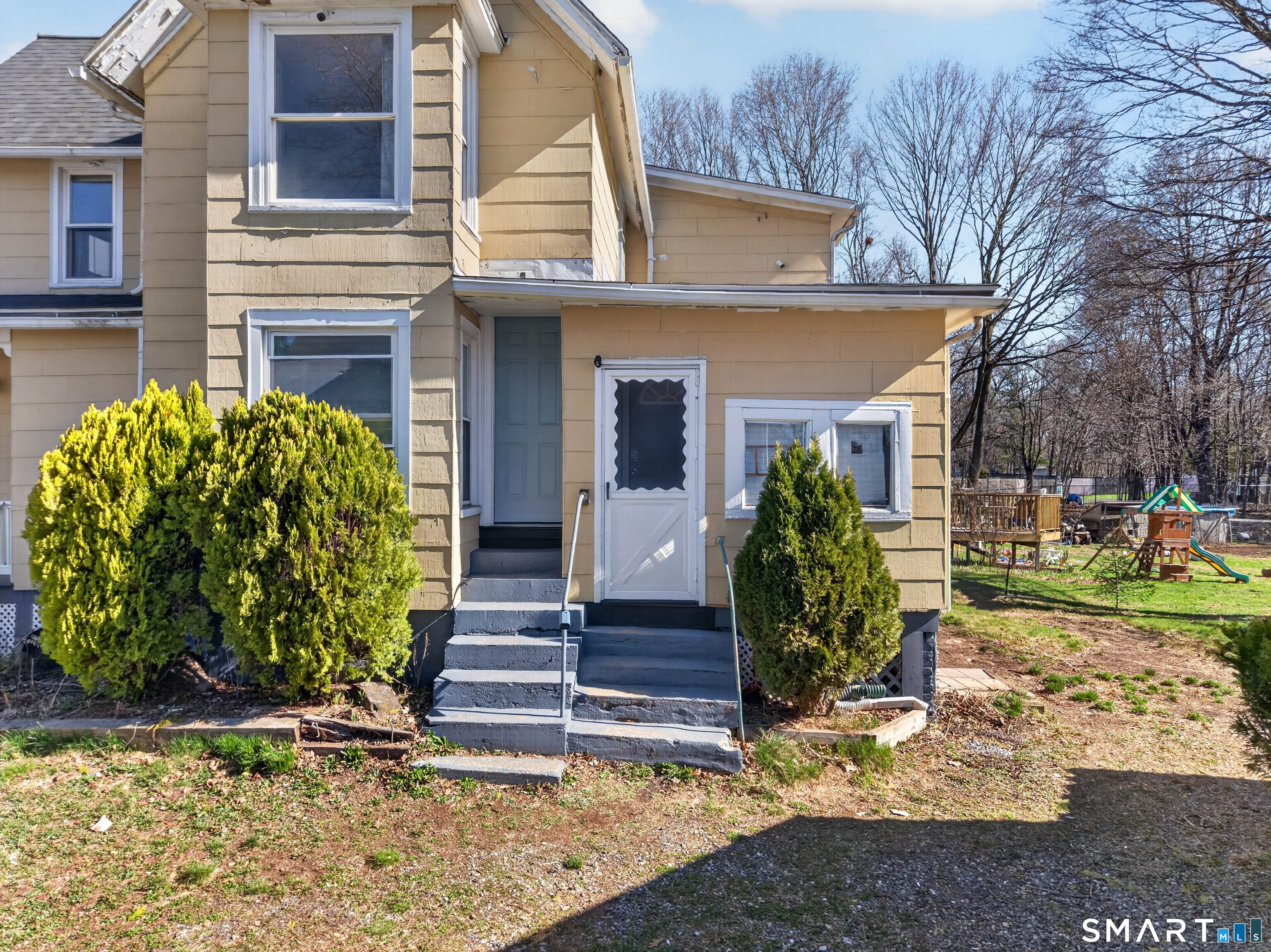 97 Woodland Street Meriden, CT 06451 - Photo 29 of 35 a view of a house with brick walls plants and large tree