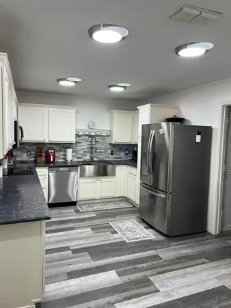 a kitchen with stainless steel appliances granite countertop a refrigerator and a stove top oven