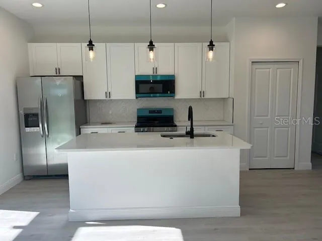 a view of a kitchen with stainless steel appliances granite countertop cabinets and a refrigerator