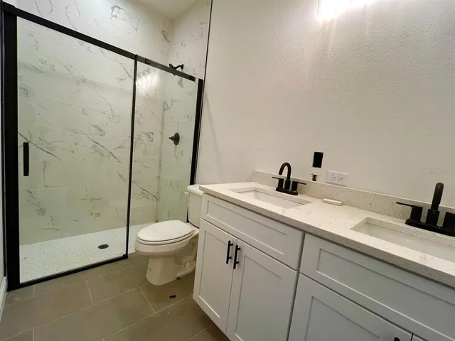 a bathroom with a shower sink mirror and toilet