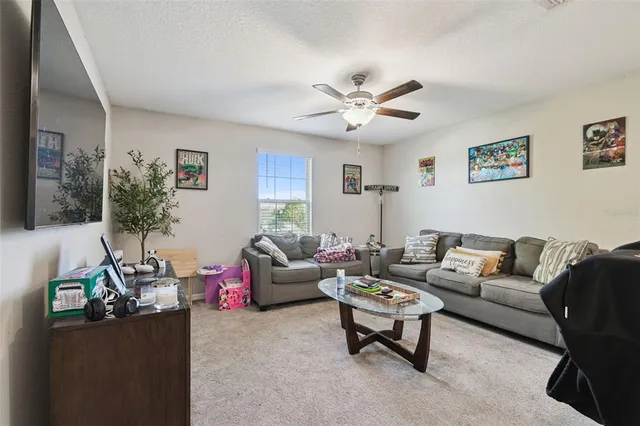 a living room with furniture and a ceiling fan