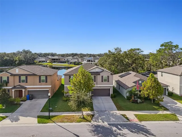 a view of a swimming pool with lawn chairs under an umbrella