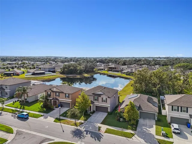 a view of a house with a big yard and potted plants