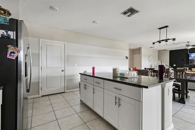 a kitchen with stainless steel appliances granite countertop white cabinets sink and a granite counter top