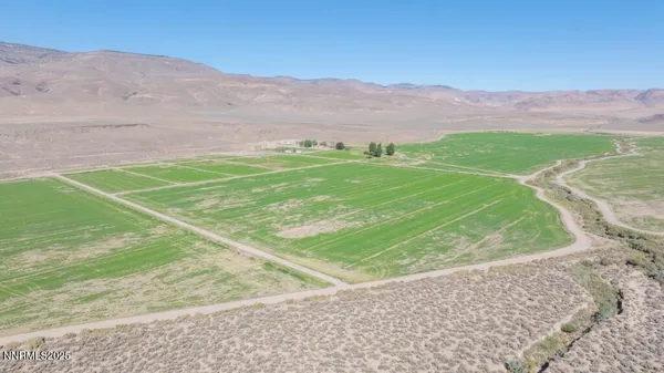 a view of a field with mountains in the background