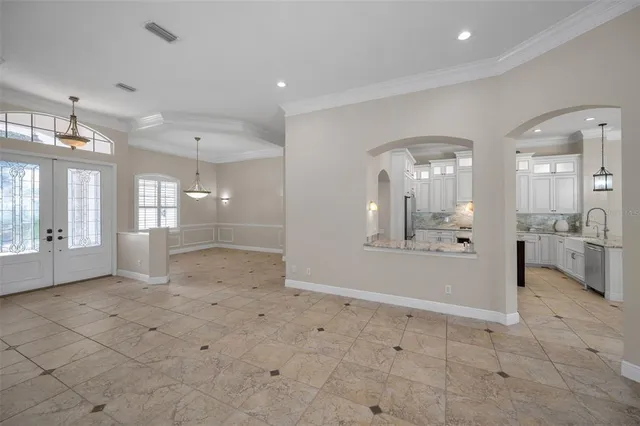 an empty room with wooden floor ceiling fan and windows