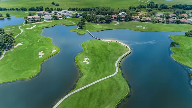an aerial view of a golf course with swimming pool and outdoor seating