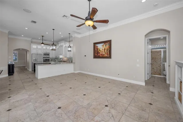 an empty room with windows and ceiling fan