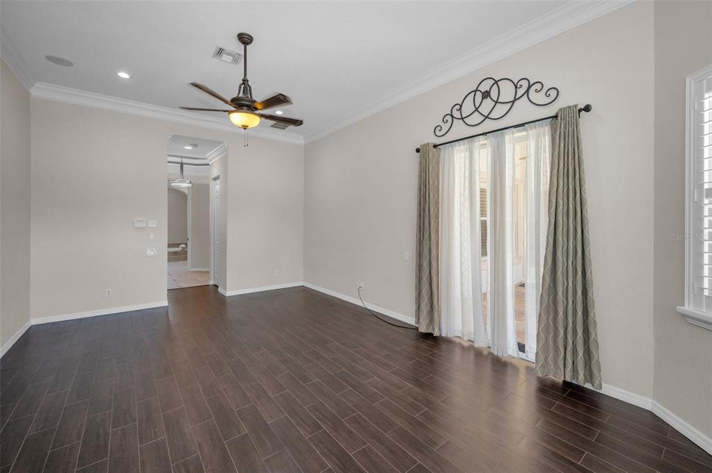 1227 Toscano Drive Trinity, FL 34655 - Photo 31 of 99 an empty room with wooden floor ceiling fan and windows