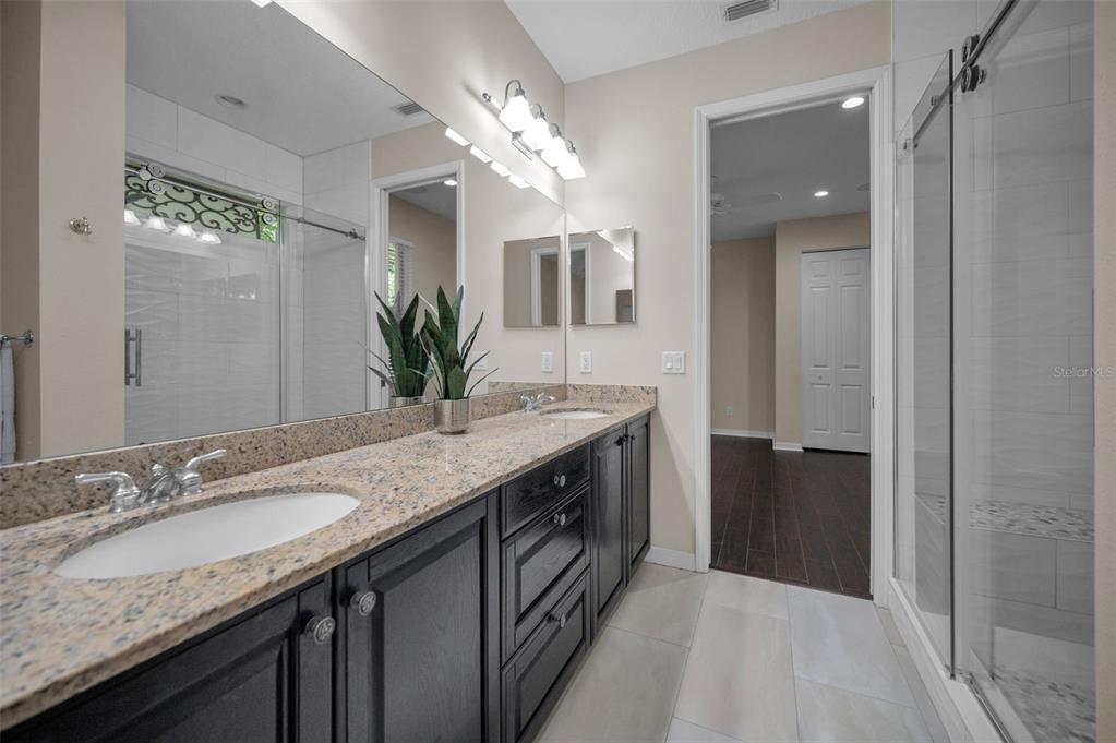 1227 Toscano Drive Trinity, FL 34655 - Photo 44 of 99 a bathroom with a granite countertop double vanity and a mirror