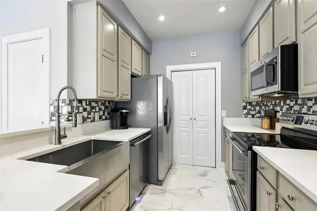 a kitchen with stainless steel appliances granite countertop a sink stove and refrigerator