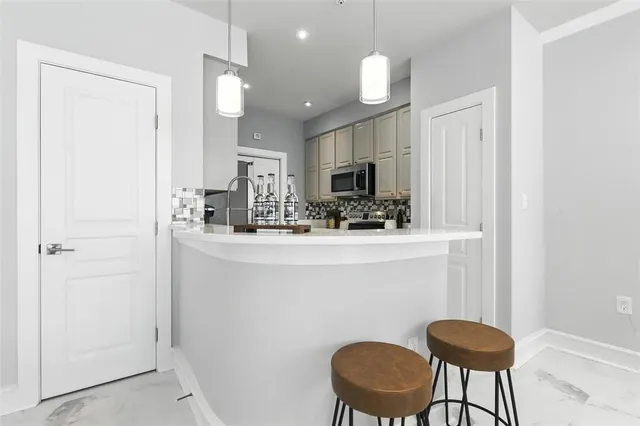 a kitchen with a table chairs refrigerator and microwave