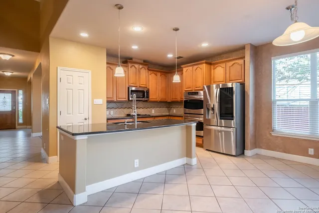 a kitchen with stainless steel appliances granite countertop a refrigerator a stove top oven a sink and dishwasher