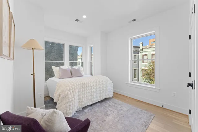 a bedroom with a couch chairs and window