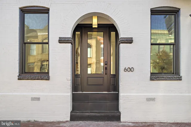 a hall way with wooden floor and stairs