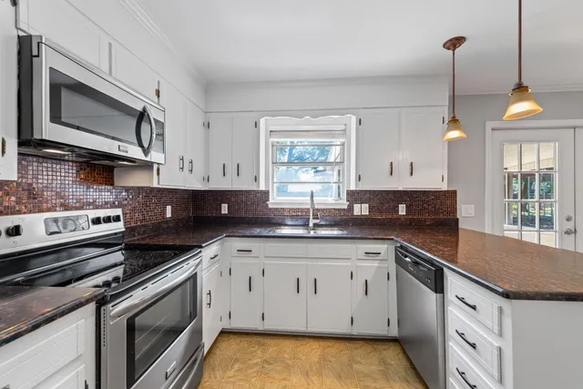 a kitchen with a sink stove and microwave