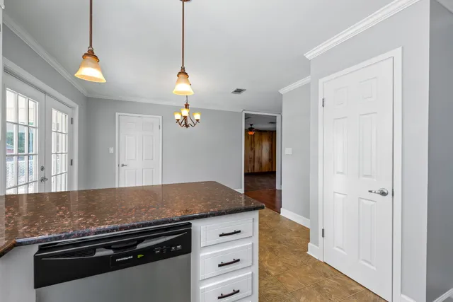 a kitchen with granite countertop a sink cabinets and wooden floor