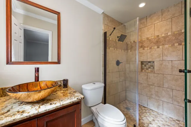 a bathroom with a granite countertop sink toilet and shower
