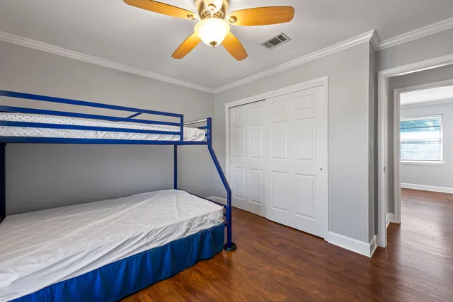a bedroom with a bed and wooden floor