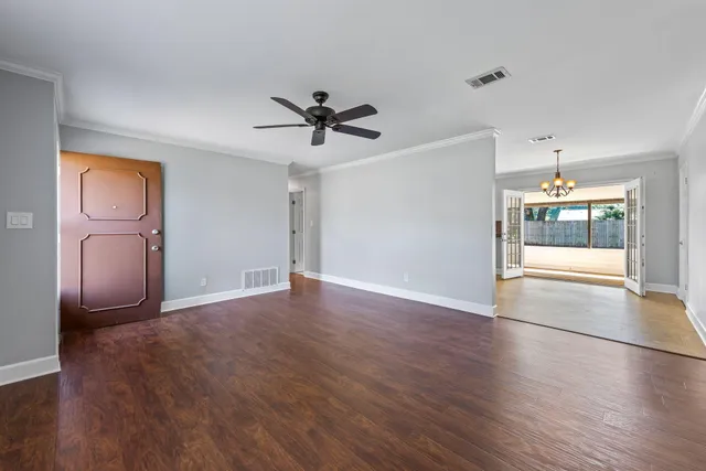 a view of a livingroom with wooden floor and a ceiling fan