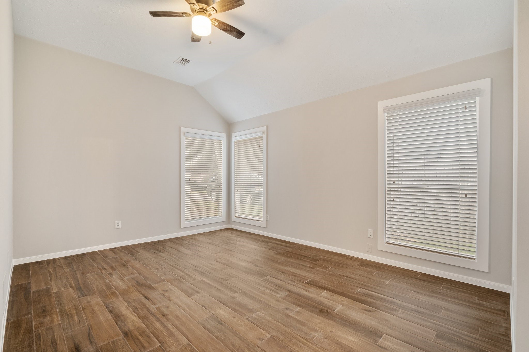 1931 Invermere Drive Spring, TX 77386 - Photo 13 of 24 an empty room with wooden floor chandelier fan and windows
