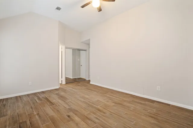 a view of an empty room with wooden floor