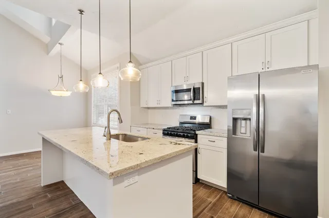 a kitchen with a sink a counter space appliances and cabinets