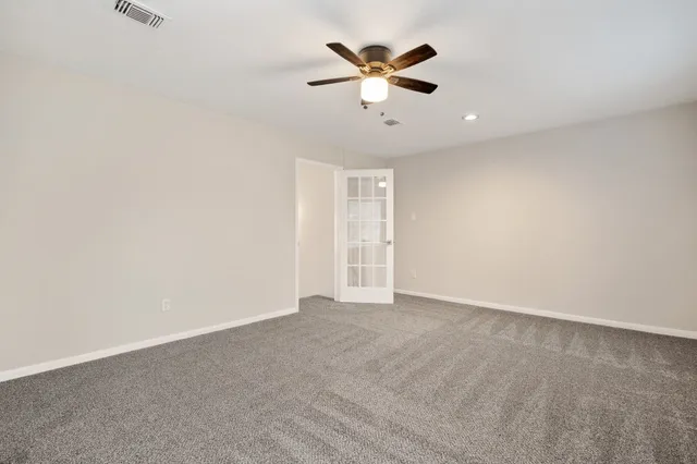 an empty room with closet and a ceiling fan