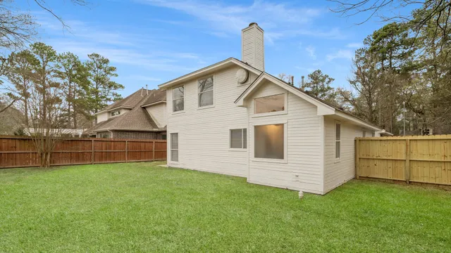 a view of a house with backyard and trees