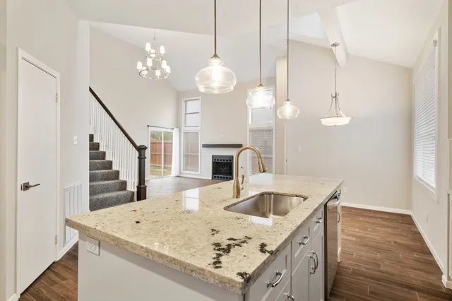 a kitchen that has a lot of white cabinets and wooden floor