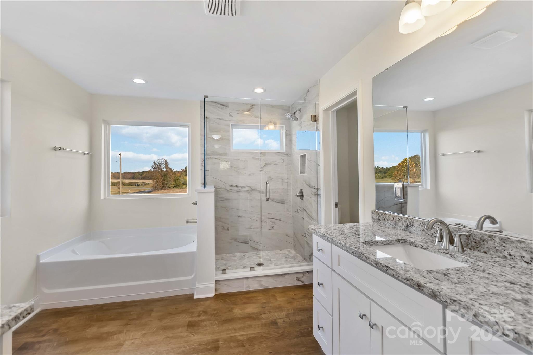 1006 Heath Helms Road Monroe, NC 28110 - Photo 32 of 48 a bathroom with a granite countertop bathtub shower sink and mirror