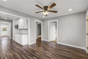 5210 Pickfair Street Houston, TX 77026 - Photo 11 of 18 a view of an empty room with wooden floor and a kitchen