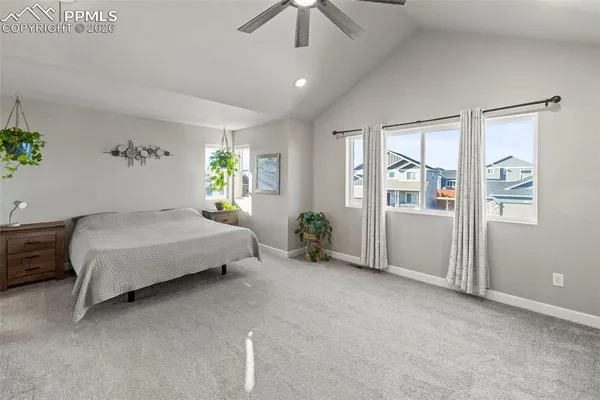 a bedroom with a large bed and a chandelier fan