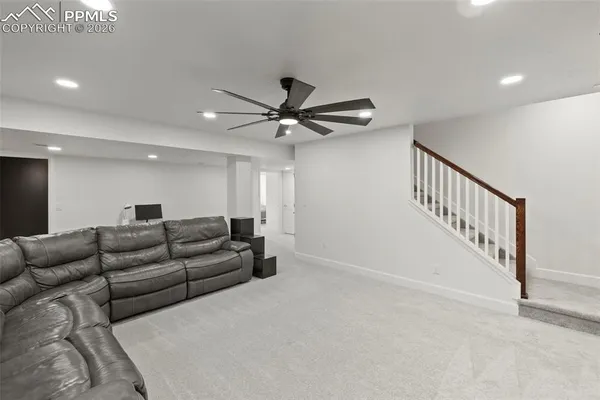 a living room with furniture and a ceiling fan