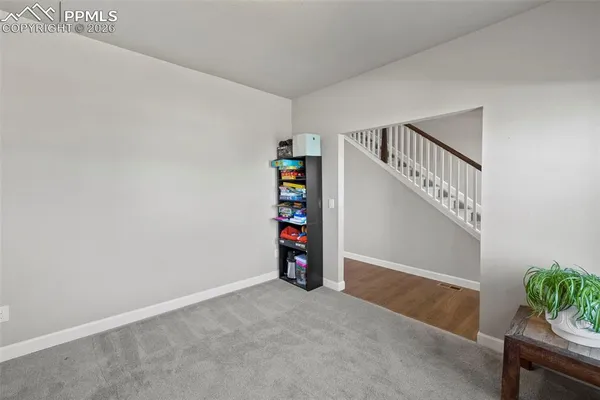 a view of an empty room with stairs and toys