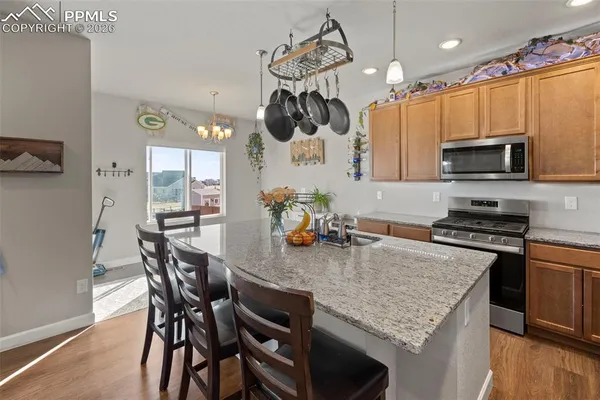 a kitchen with stainless steel appliances granite countertop a kitchen island a stove a table and chairs in it
