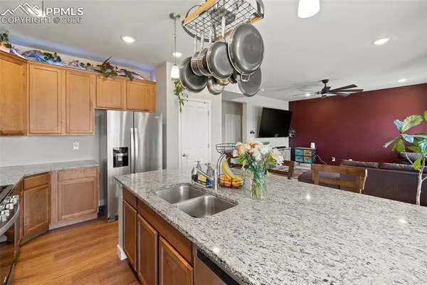 a kitchen with stainless steel appliances granite countertop a sink a stove top oven a counter space and cabinets